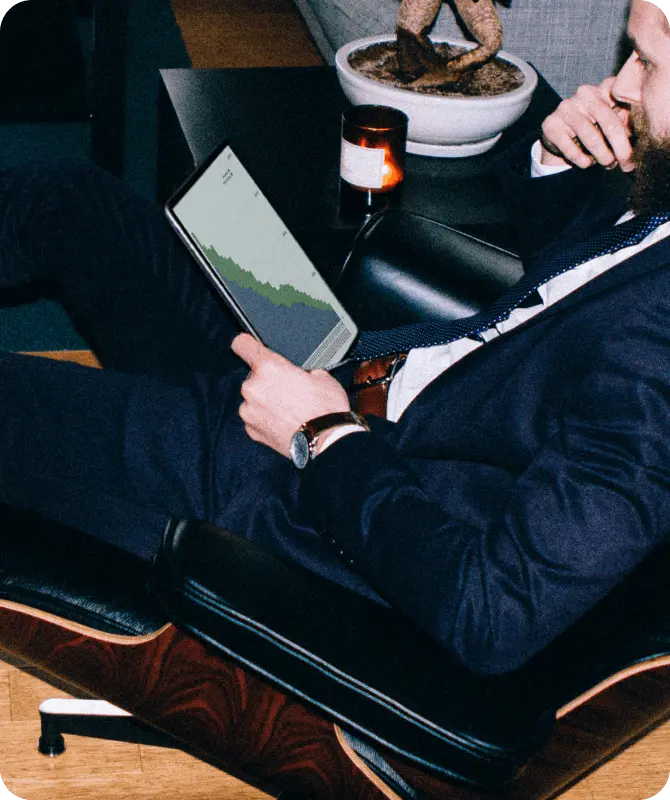 Man sitting on a chair looking at a tablet